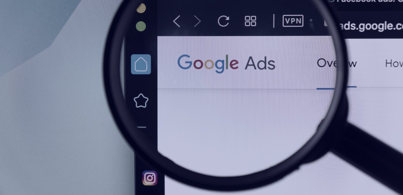 A magnifying glass held over a browser window showing a Google Ads account.